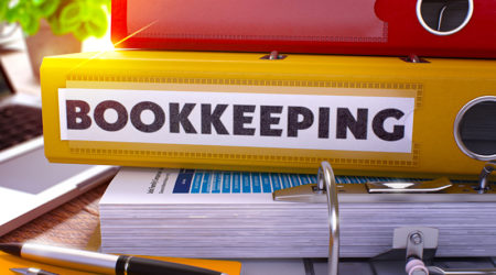 Yellow Ring Binder with Inscription Bookkeeping on Background of Working Table with Office Supplies and Laptop. Bookkeeping Business Concept on Blurred Background. 3D Render.